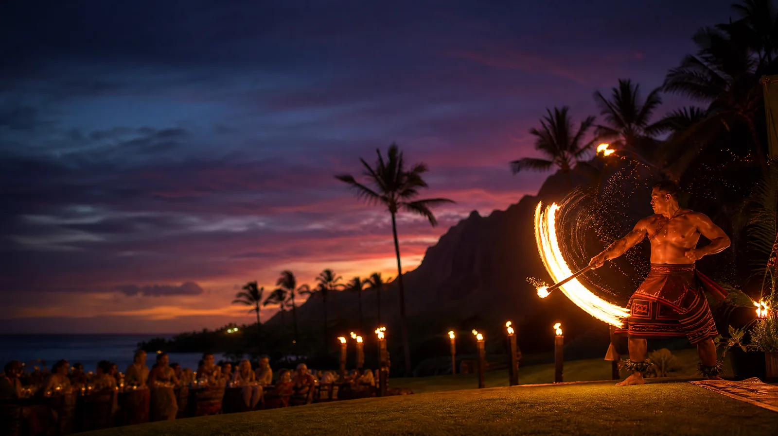 Feuermessertänzer bei einem Fackel-Luau auf Kauai bei Sonnenuntergang